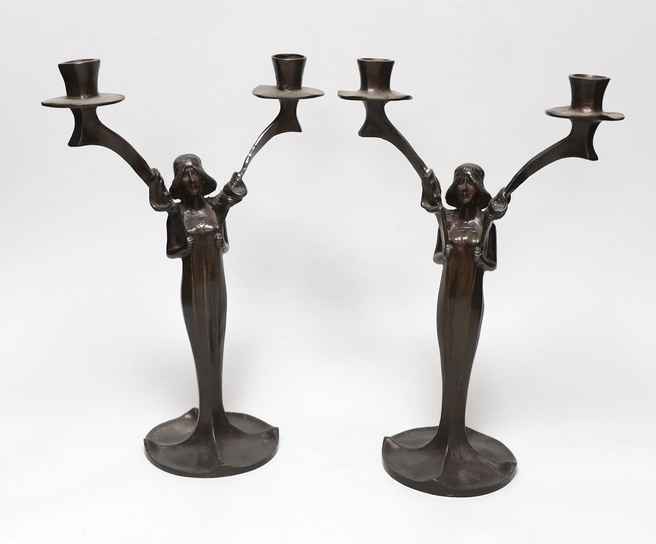 After Jules Moigniez (1835-1894) - a pair of bronze two branch candelabra, signed, dated 1902, 34cm high